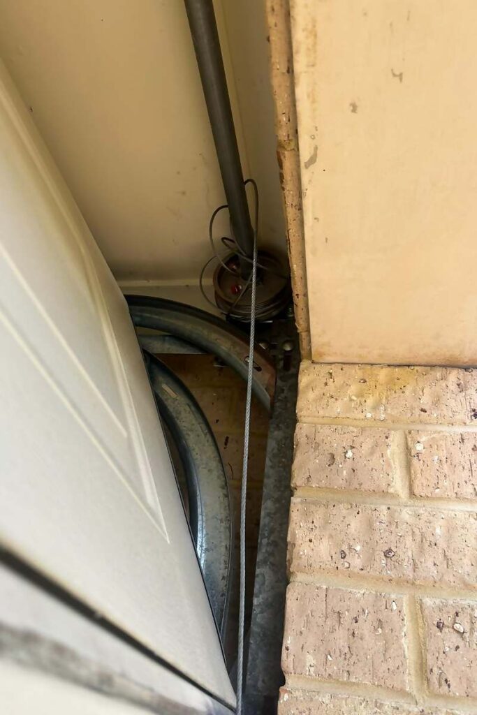 Slack lift cable at the drum on a sectional garage door