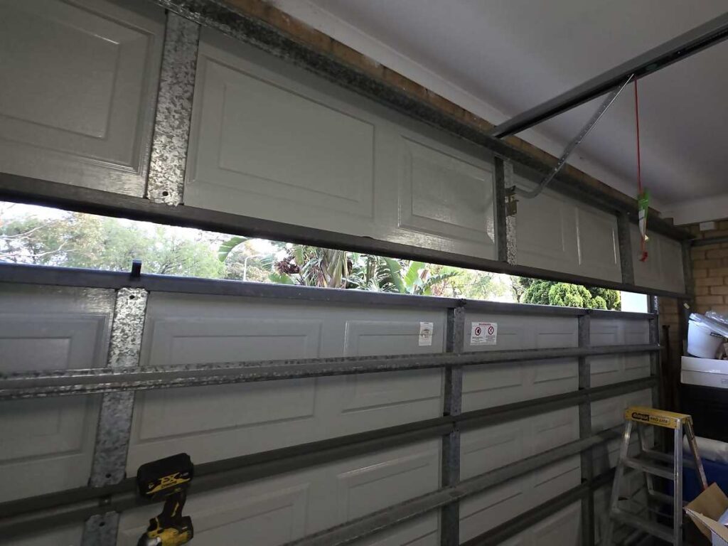 Hinges and brackets along the panel joins of a sectional garage door in Patterson Lakes