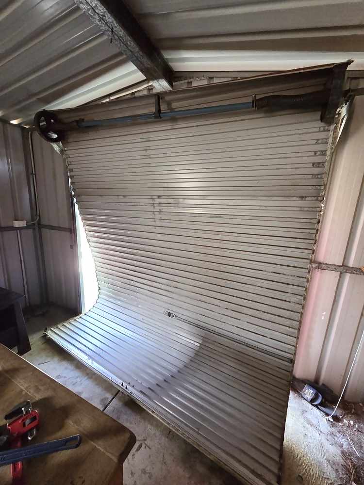 Buckled roller door curtain hanging inside a shed in Armadale, Perth