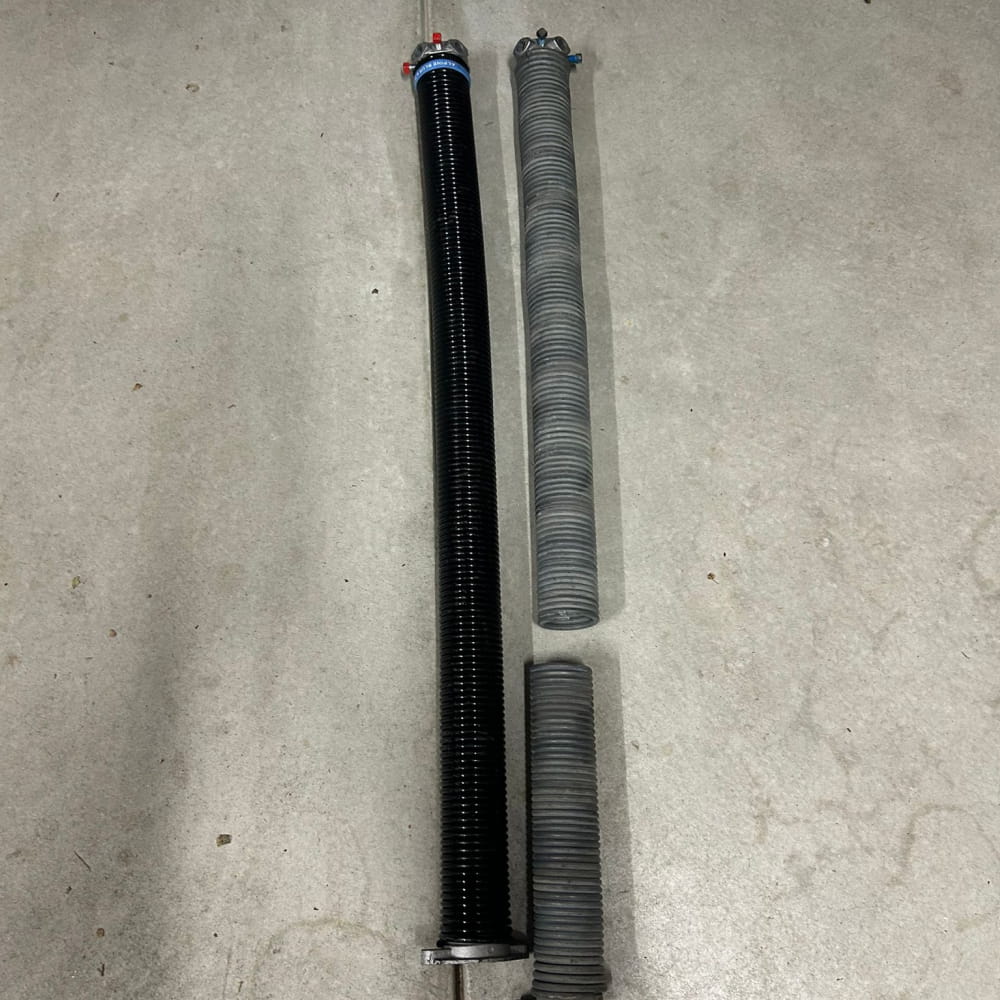 New torsion spring next to the old broken spring replaced on a garage door in Applecross, Perth